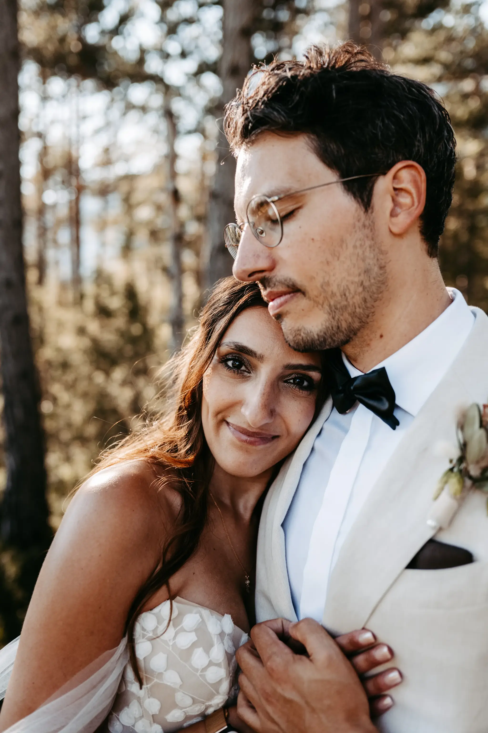 Bride and groom embracing tenderly in a forest wedding portrait near the Stöttlalm in Mieming, Tyrol