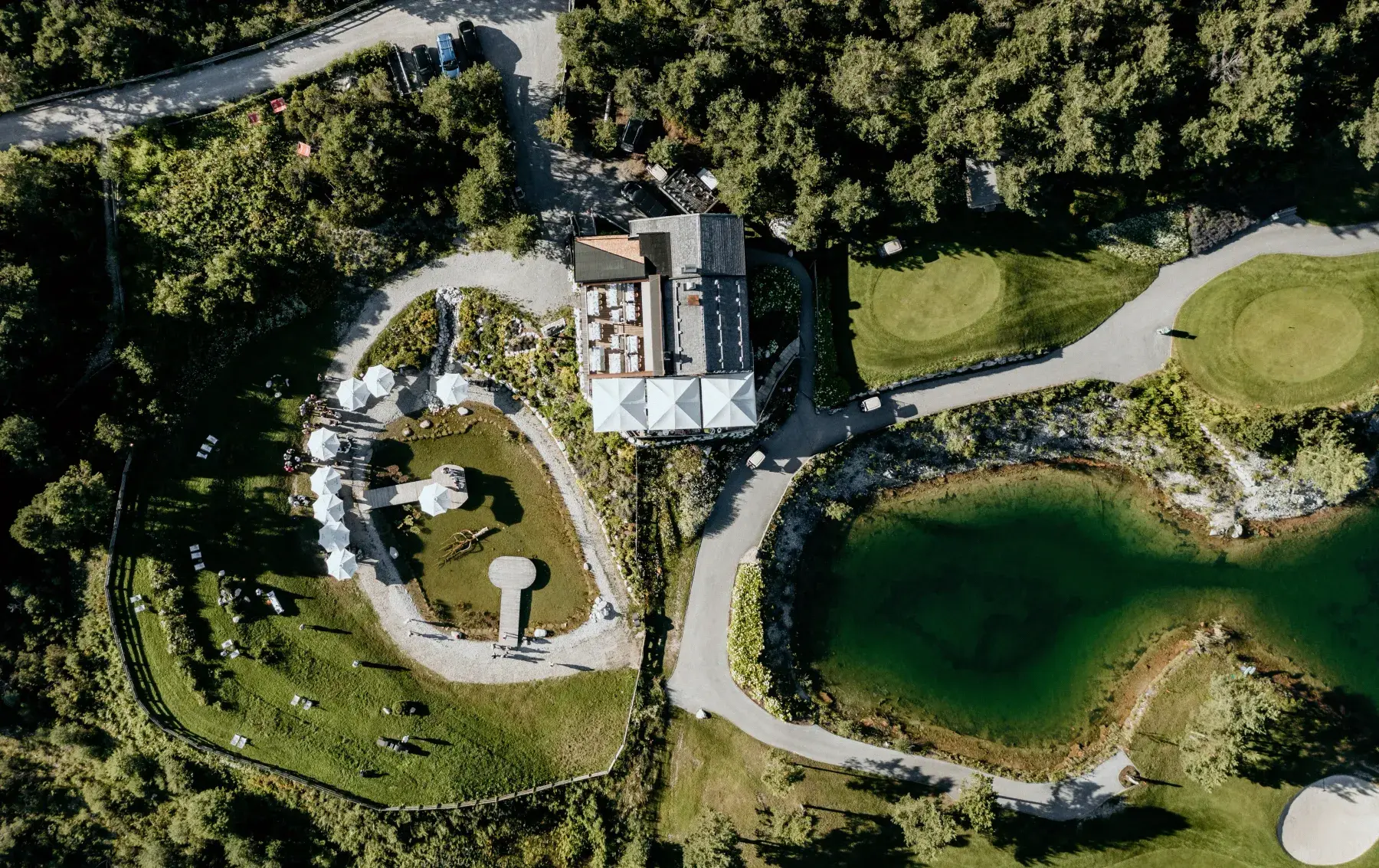 Aerial view of the Stöttlalm with terrace, mountain lake Stöttlalmsee and golf course on the Mieming Plateau in Tyrol