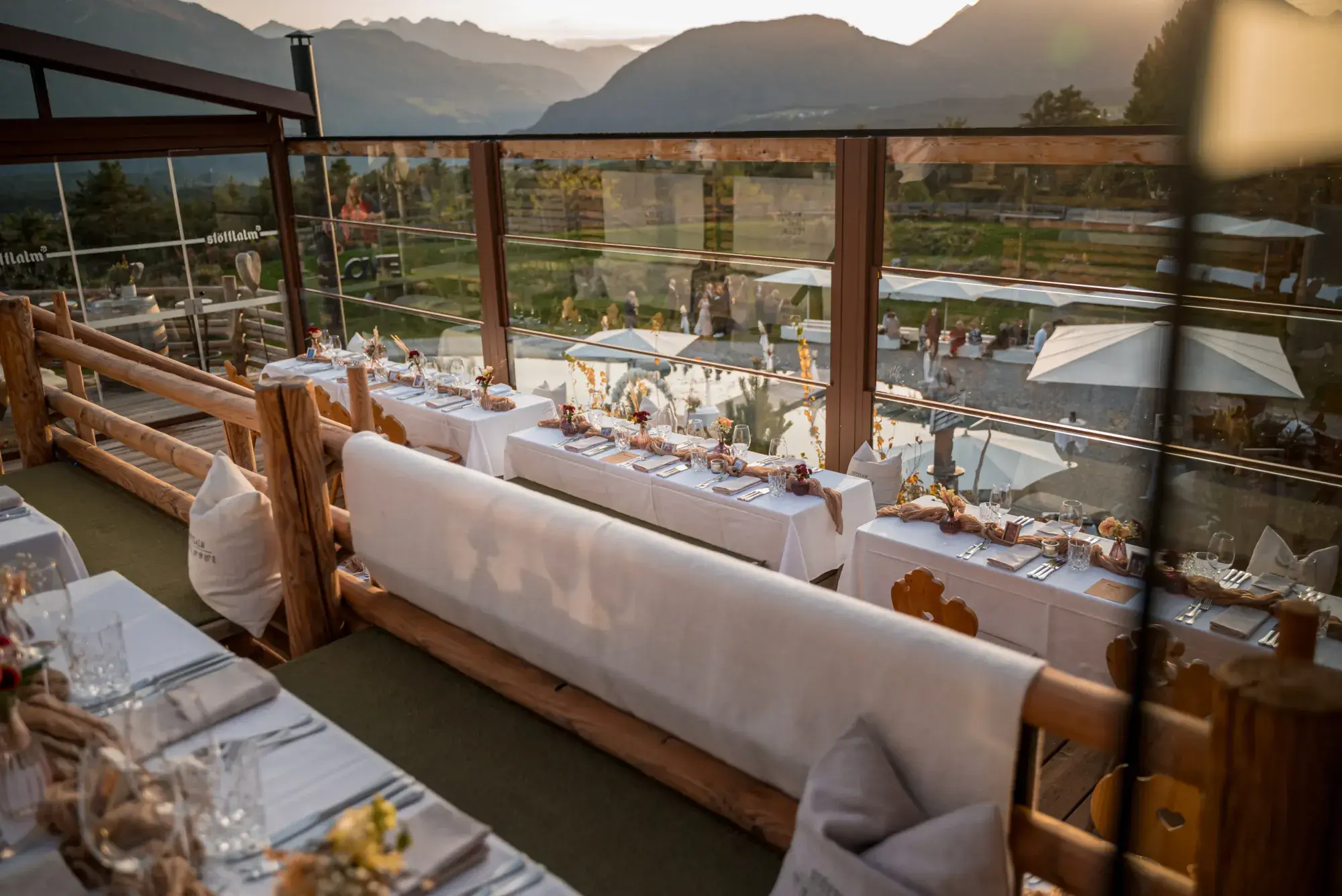 Festively laid tables on the covered panorama terrace of the Stöttlalm with a wide mountain view over the Mieminger Plateau