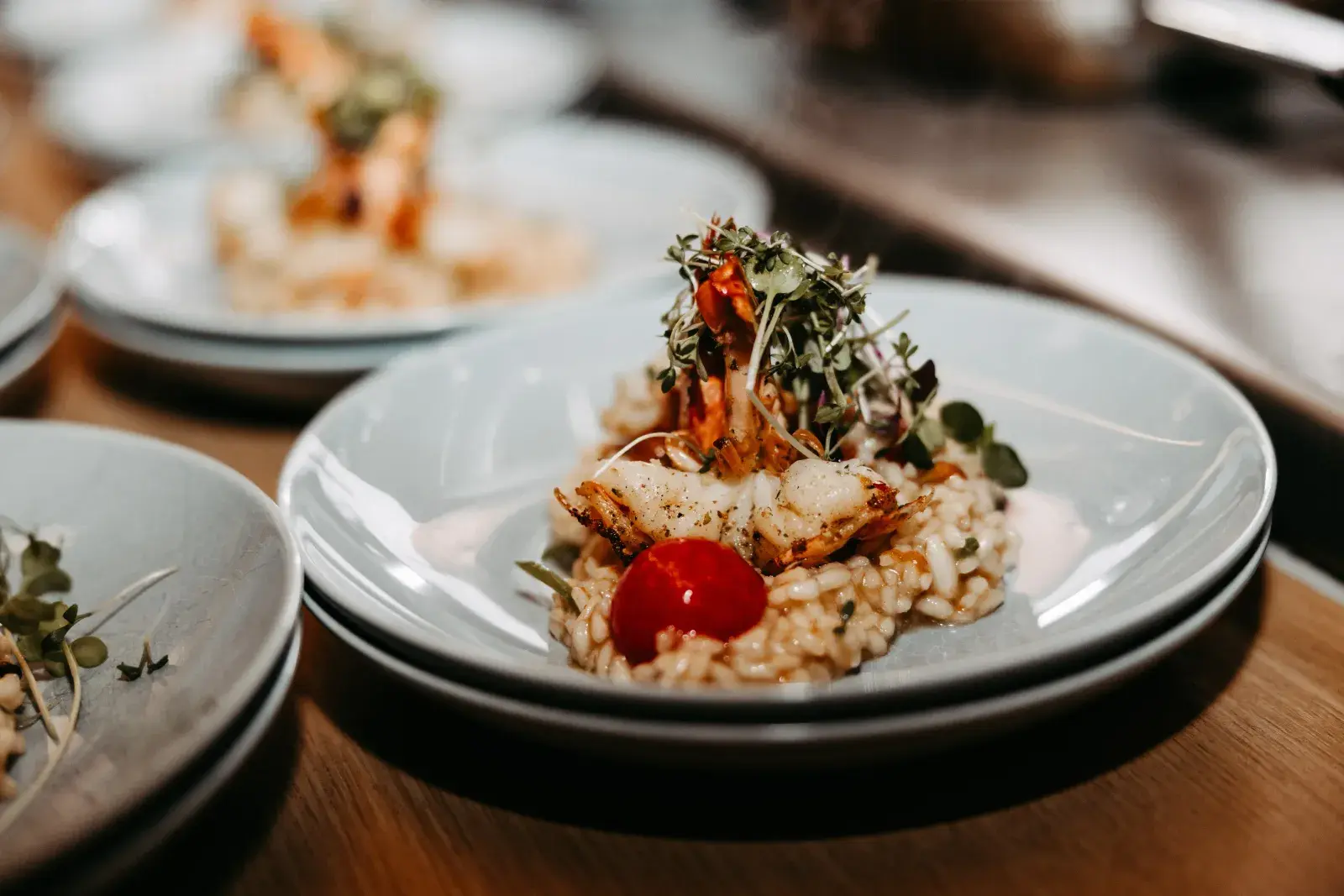 Gourmet risotto with grilled prawns, cherry tomato and microgreens, finely plated at the Stöttlalm