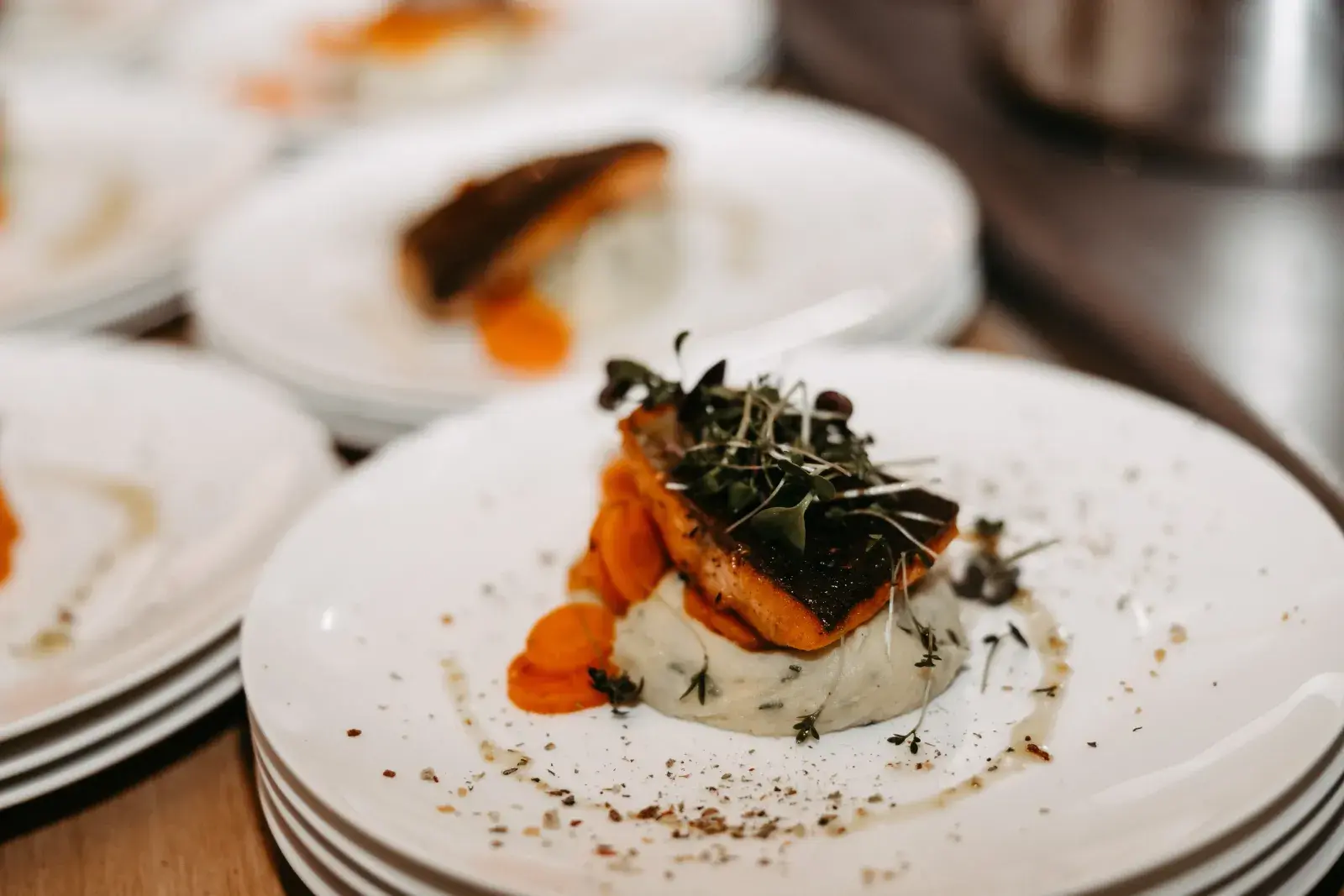 Pan-fried salmon fillet on herb purée with carrots and microgreens, a plated lunch dish at the Stöttlalm